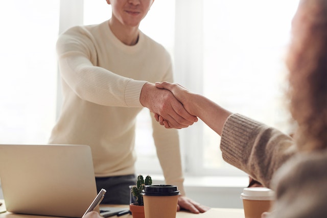 people shaking hands across desk